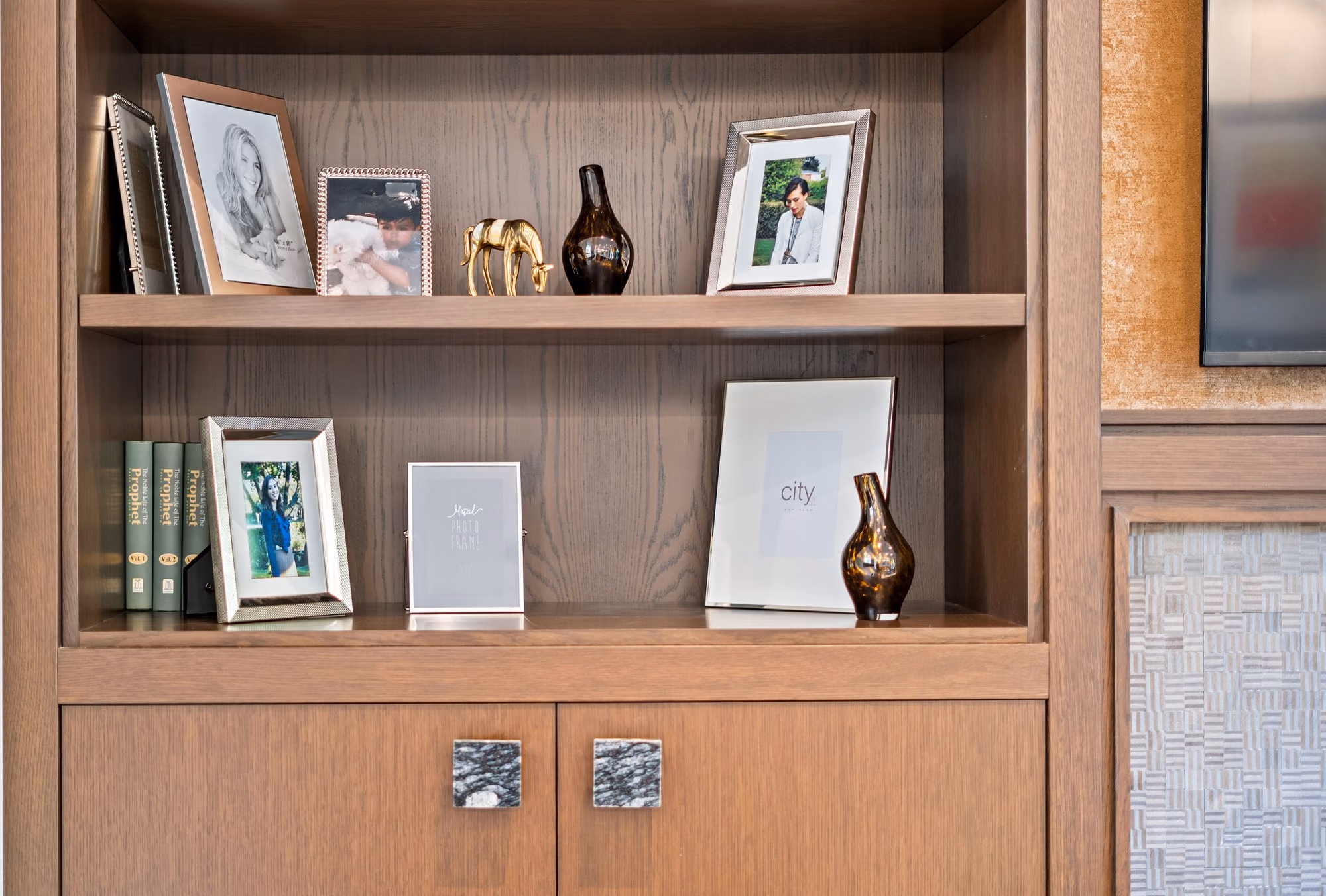 Built-in wood shelving styled with frames and objects